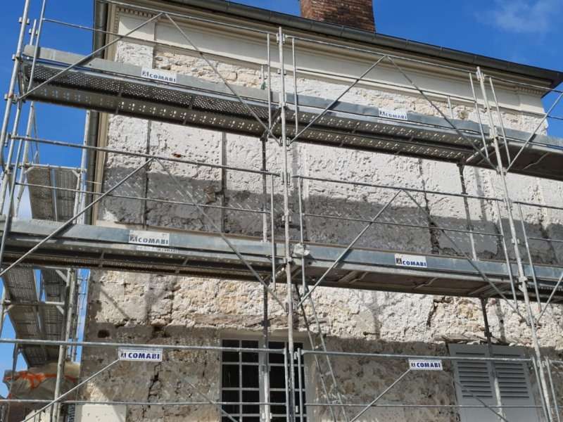 Pose d'un enduit plâtre chaux et piochage de façade